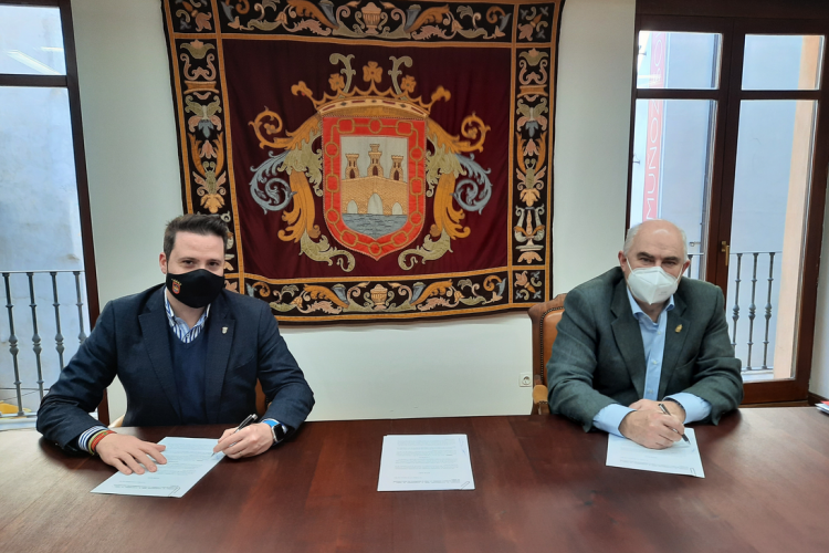 Fotografía de los dos representantes en un despacho firmando el convenio sentados en una mesa