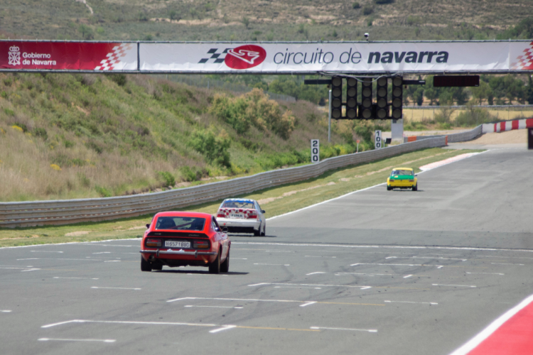 Fotografía exterior de un circuito de carreras donde aparecen tres coches.