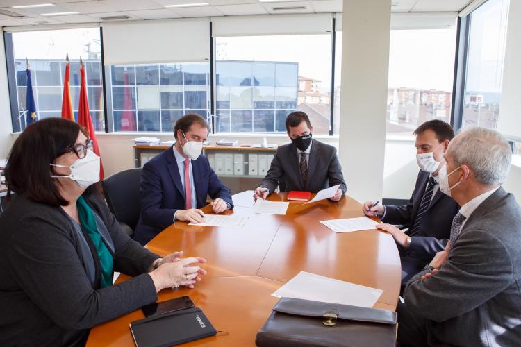 Fotografía interior de cuatro hombres y una mujer sentados alrededor de una mesa.