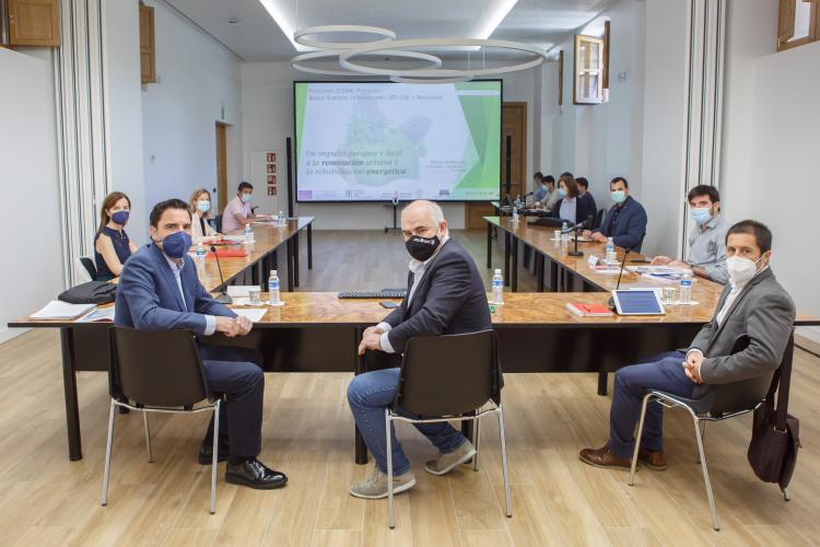 Fotografía interior de varias personas sentadas en una mesa durante la reunión