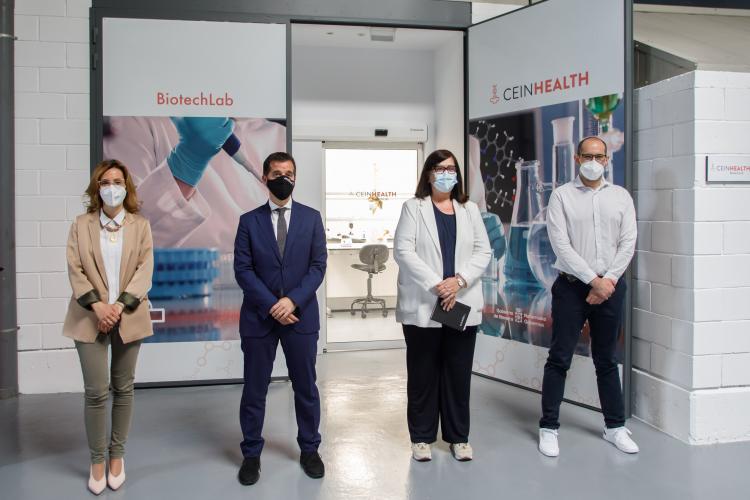 Fotografía interior con dos hombres y dos mujeres de pie a la entrada del laboratorio. 