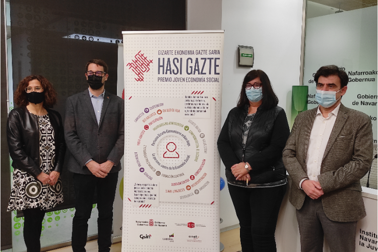 Fotografia de varias personas posando junto al cartel de los premios Hasi Gazte