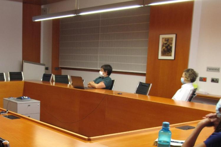 Fotografía de una sala de reuniones donde están sentadas tres personas