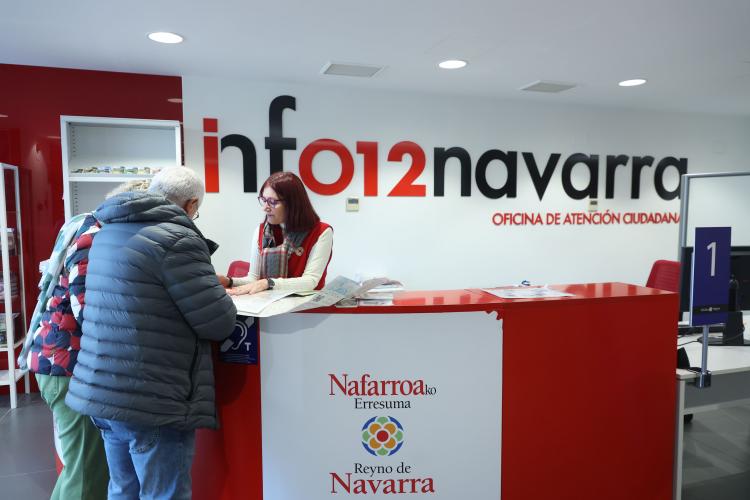 Fotografía donde aparecen una pareja de señores mayores siendo atendidos en el mostrador de la oficina de atención ciudadana de Tudela