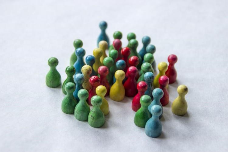 Imagen de un grupo de peones de madera de colores, significando un equipo diverso.
