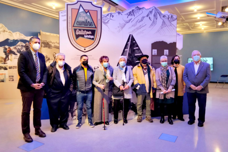 Fotografía de varias personas posando frente a un mural de la exposición