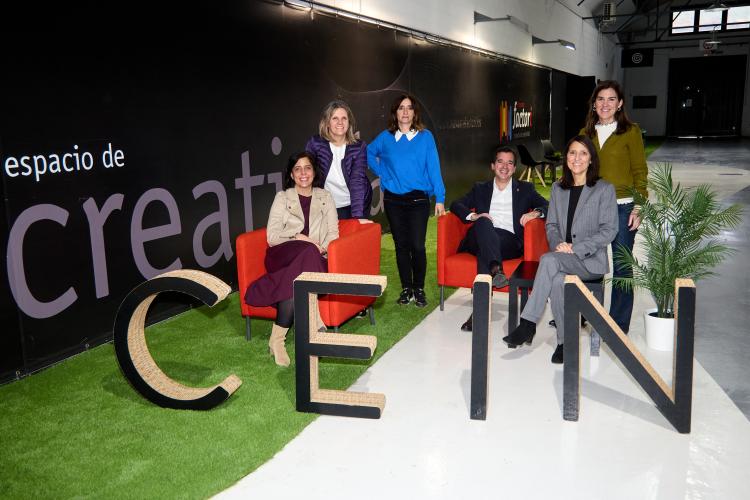 Miembros de CEIN posando detrás del logo del mismo