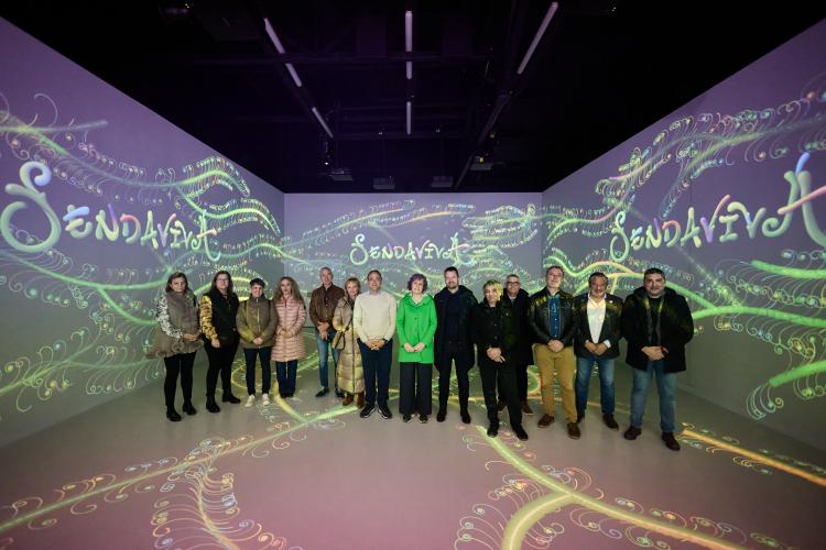 Grupo de personas en una sala ambientada con el logo de Sendaviva
