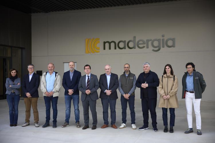 Personas posando delante del logo de la empresa