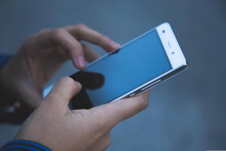 Las manos de una persona sosteniendo un teléfono móvil