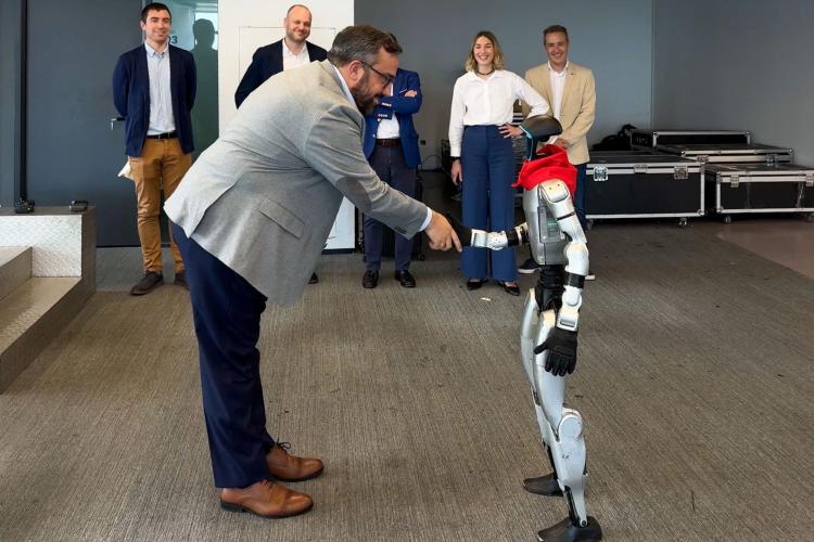 Un robot saludando con la mano a una persona
