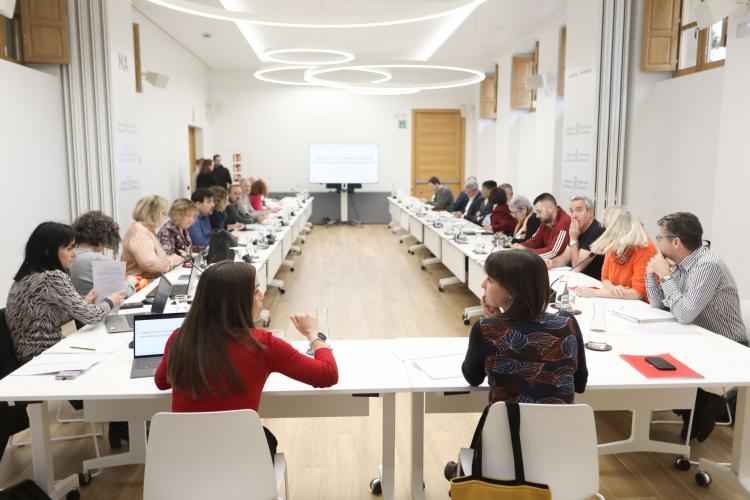 Grupo de gente reunido en un conjunto de mesas en forma de U