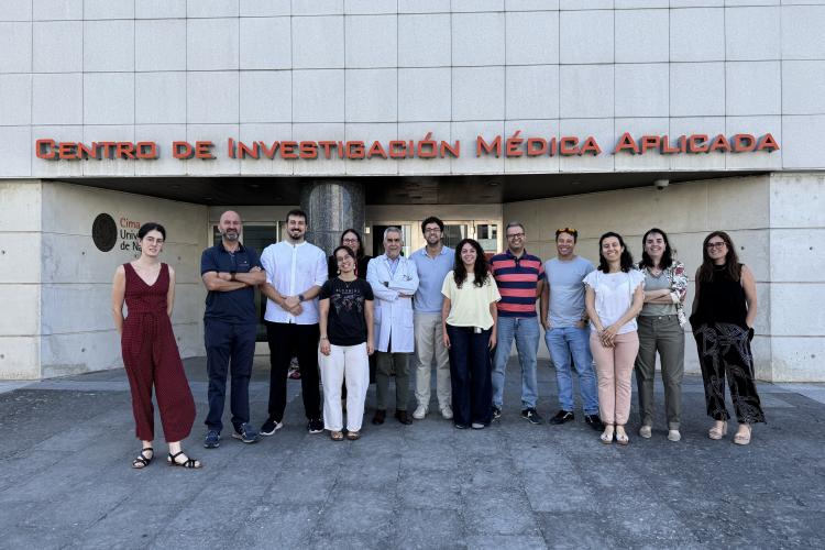 Un grupo de gente posando delante de la entrada del Centro de Investigación Médica Aplicada