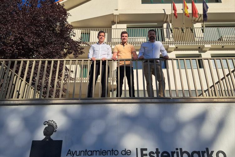 3 personas posando desde lo alto de un balcón